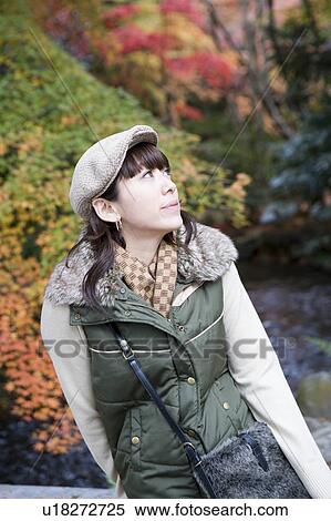 Stock Photography - Young woman looking up, Kamigamo Shrine, Kyoto Prefecture, Japan. Fotosearch