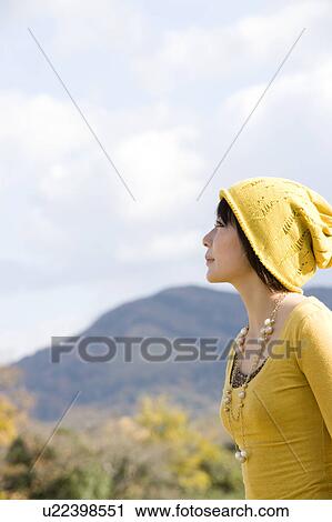 Stock Image - Young woman looking up. Fotosearch