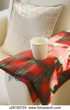 Picture - Cup of milk on sofa. Fotosearch