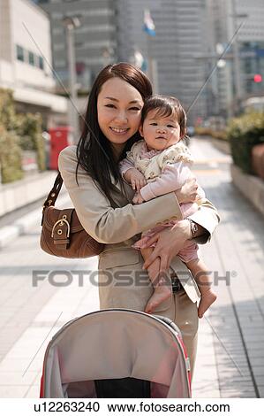 Businesswoman holding baby View Large Photo Image Stock Image - Businesswoman holding baby. Fotosearch