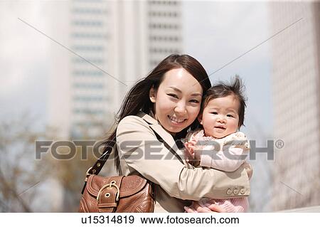 Businesswoman holding baby View Large Photo Image Stock Photo - Businesswoman holding baby. Fotosearch