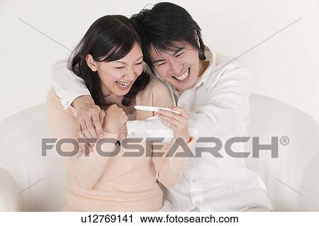 Couple looking at pregnancy test View Large Photo Image Stock Image - Couple looking at pregnancy test. Fotosearch