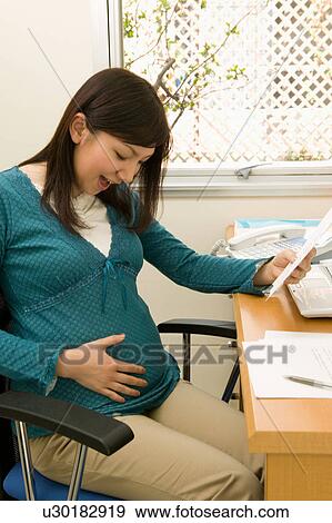 Pregnant woman at work View Large Photo Image Stock Photo - Pregnant woman at work. Fotosearch