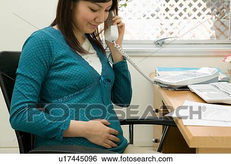 Pregnant woman at work View Large Photo Image Stock Photograph - Pregnant woman at work. Fotosearch