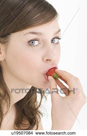 Young woman eating strawberry View Large Photo Image Picture - Young woman eating strawberry. Fotosearch