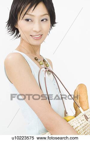 Stock Photography - Young woman holding bag. Fotosearch