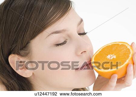 Young woman holding orange View Large Photo Image Stock Image - Young woman holding orange. Fotosearch