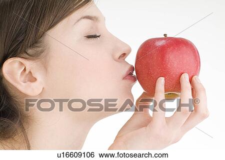 Young woman kissing apple View Large Photo Image Stock Photograph - Young woman kissing apple. Fotosearch