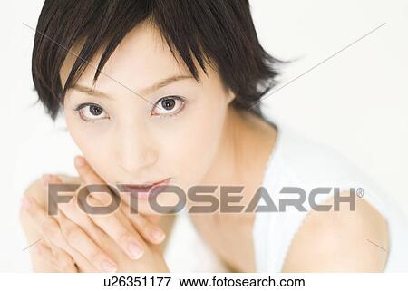 Stock Photo - Young woman looking at camera. Fotosearch