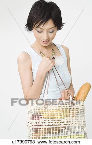 Young woman looking in shopping bag View Large Photo Image Stock Photo - Young woman looking in shopping bag. Fotosearch