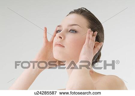 Stock Photo - Young woman massaging temples. Fotosearch