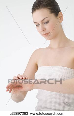 Young woman rubbing lotion on hands View Large Photo Image Stock Image - Young woman rubbing lotion on hands. Fotosearch