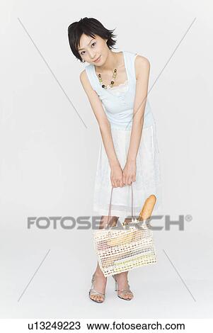 Young woman standing with bag View Large Photo Image Stock Image - Young woman standing with bag. Fotosearch