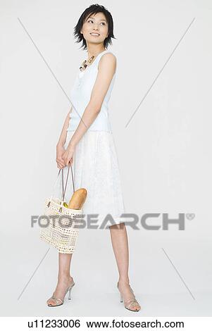 Young woman standing with bag View Large Photo Image Stock Photograph - Young woman standing with bag. Fotosearch