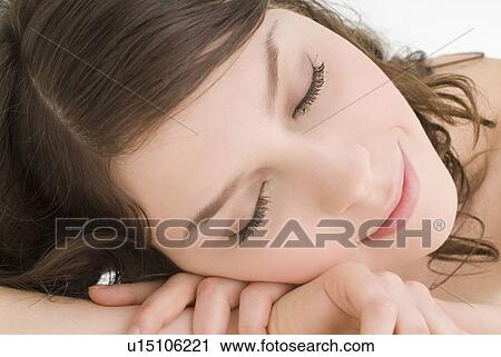 Stock Image - Young woman with eyes closed. Fotosearch