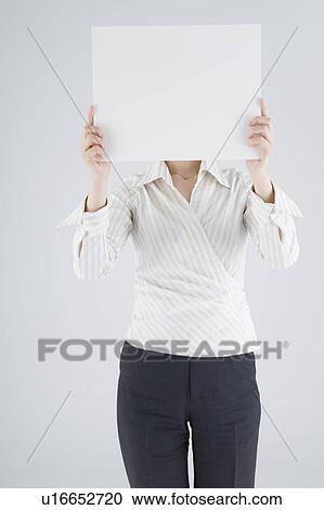 Stock Image - Businesswoman holding blank placard. Fotosearch
