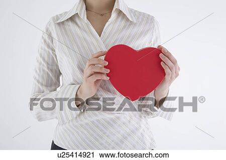 Businesswoman holding heart-shaped box View Large Photo Image Stock Image - Businesswoman holding heart-shaped box. Fotosearch