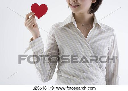 Stock Photo - Businesswoman holding heart-shaped paper. Fotosearch