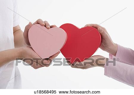 Man and woman holding heart-shaped boxes View Large Photo Image Stock Photography - Man and woman holding heart-shaped boxes. Fotosearch