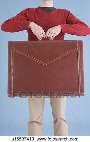 Man holding suitcase View Large Photo Image Stock Photo - Man holding suitcase. Fotosearch