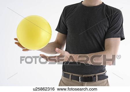 Stock Photograph - Man holding yellow balloon. Fotosearch