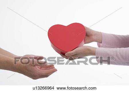Picture - Woman giving man heart-shaped box. Fotosearch