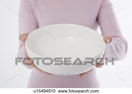 Stock Image - Woman holding empty bowl. Fotosearch