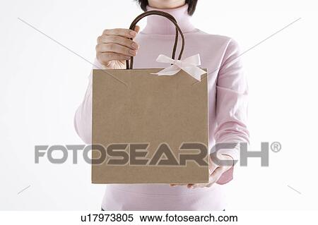 Stock Photography - Woman holding paper bag. Fotosearch