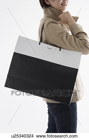 Woman holding shopping bag View Large Photo Image Picture - Woman holding shopping bag. Fotosearch