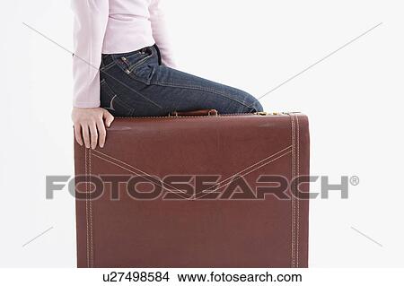 Woman sitting on suitcase View Large Photo Image Picture - Woman sitting on suitcase. Fotosearch