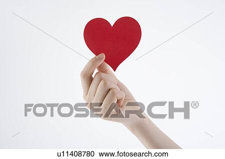 Woman's hand holding heart-shaped paper View Large Photo Image Stock Image - Woman's hand holding heart-shaped paper. Fotosearch