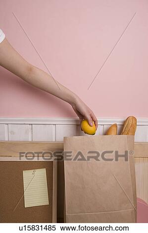 Woman's hand putting lemon in paper bag View Large Photo Image Stock Photography - Woman's hand putting lemon in paper bag. Fotosearch