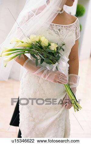 Stock Image - A bride holding a bouquet. Fotosearch