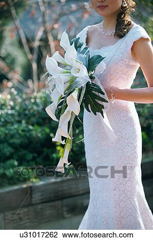 Stock Image - A bride holding a bouquet. Fotosearch