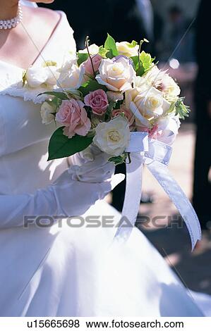 Stock Photo - A bride holding a bouquet. Fotosearch