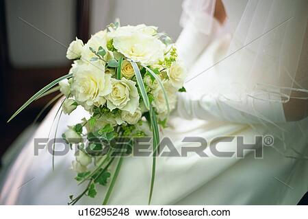 Stock Photo - A bride holding a bouquet. Fotosearch