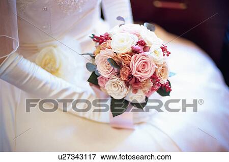 A bride holding a bouquet View Large Photo Image Stock Photo - A bride holding a bouquet. Fotosearch