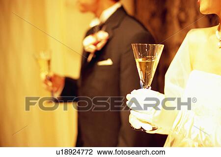 Stock Image - Bride and groom holding a glass of champagne. Fotosearch