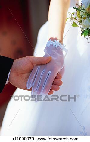 Groom holding a hand of a bride View Large Photo Image Stock Photo - Groom holding a hand of a bride. Fotosearch