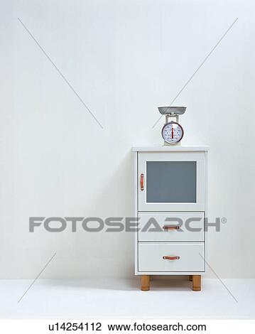 A scale on white cabinet against wall View Large Photo Image Stock Image - A scale on white cabinet against wall. Fotosearch