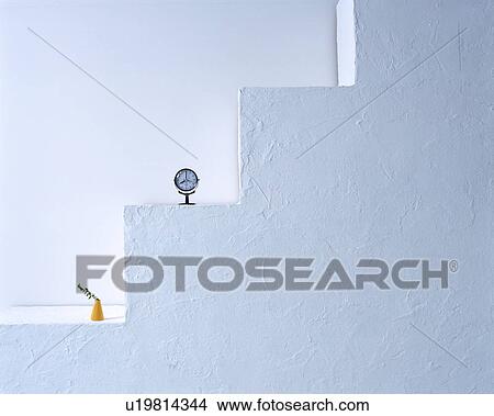 A tiny clock and a plant on steps against wall View Large Photo Image Picture - A tiny clock and a plant on steps against wall. Fotosearch