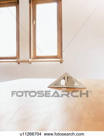 A triangular object on wooden table View Large Photo Image Picture - A triangular object on wooden table. Fotosearch