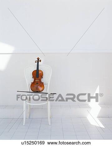 A violin and a bow on a chair View Large Photo Image Stock Photo - A violin and a bow on a chair. Fotosearch