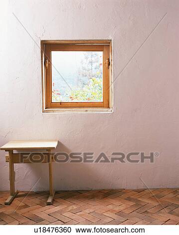 A wooden table kept against wall under windowpane View Large Photo Image Stock Image - A wooden table kept against wall under windowpane. Fotosearch