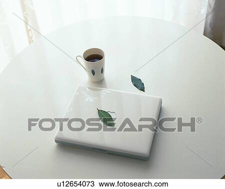 Notebook computer and a cup of coffee on table View Large Photo Image Stock Image - Notebook computer and a cup of coffee on table. Fotosearch