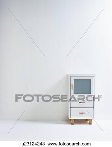 Stock Image - Small white cabinet on wall. Fotosearch