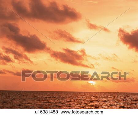 Stock Photo - Cloudy sky at sunset in Maldives. Fotosearch