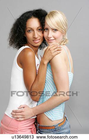 Blond and dark-haired woman embracing each other, looking at camera View Large Photo Image Stock Image - Blond and dark-haired woman embracing each other, looking at camera. Fotosearch