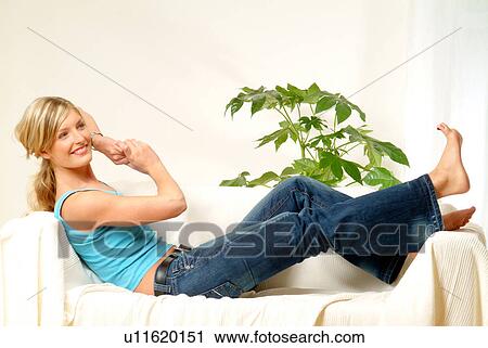 Woman relaxing on sofa, looking at her toes View Large Photo Image Stock Image - Woman relaxing on sofa, looking at her toes. Fotosearch