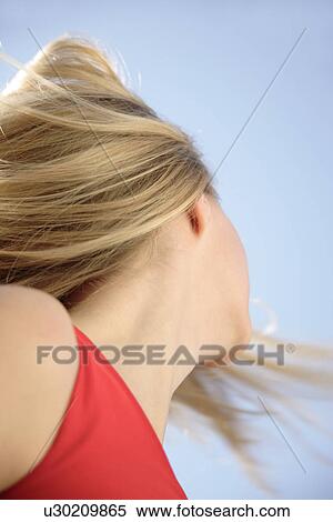 Young woman throwing her long blond hair in front of blue sky, low angle view View Large Photo Image Stock Photography - Young woman throwing her long blond hair in front of blue sky, low angle view. Fotosearch